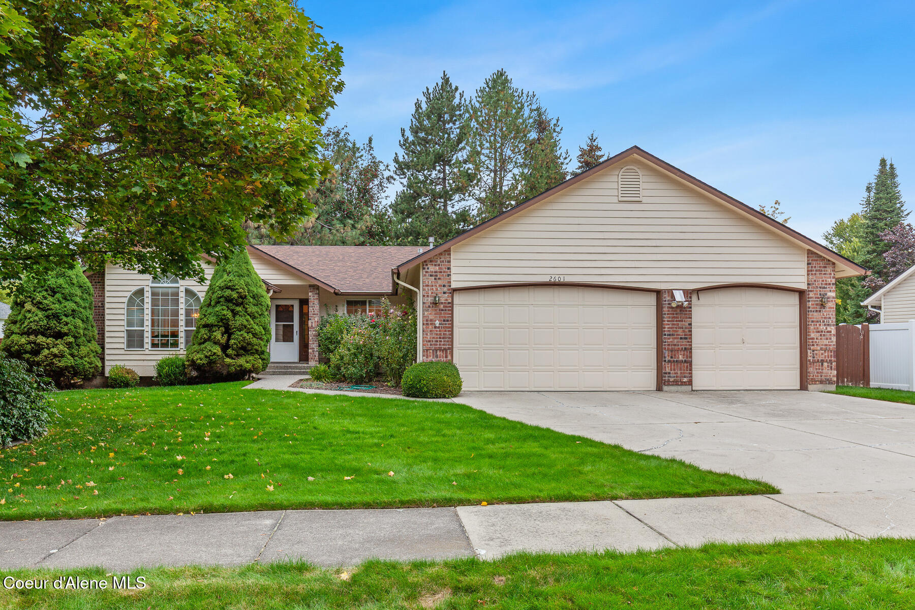 Single-story home with brick accents, a two-car garage, and a landscaped front lawn.