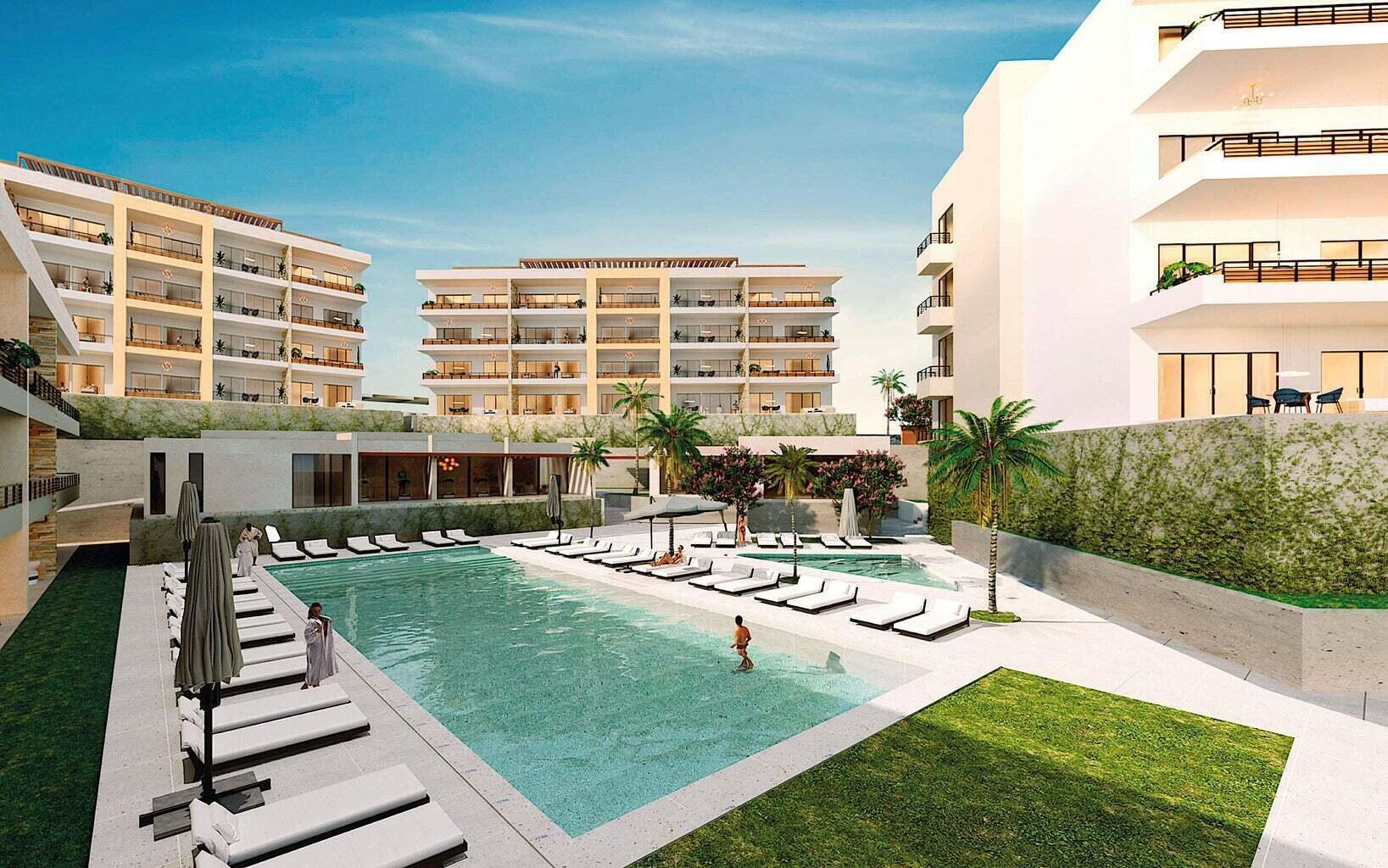 Condominium pool courtyard with white loungers, palm trees, and modern apartment buildings.