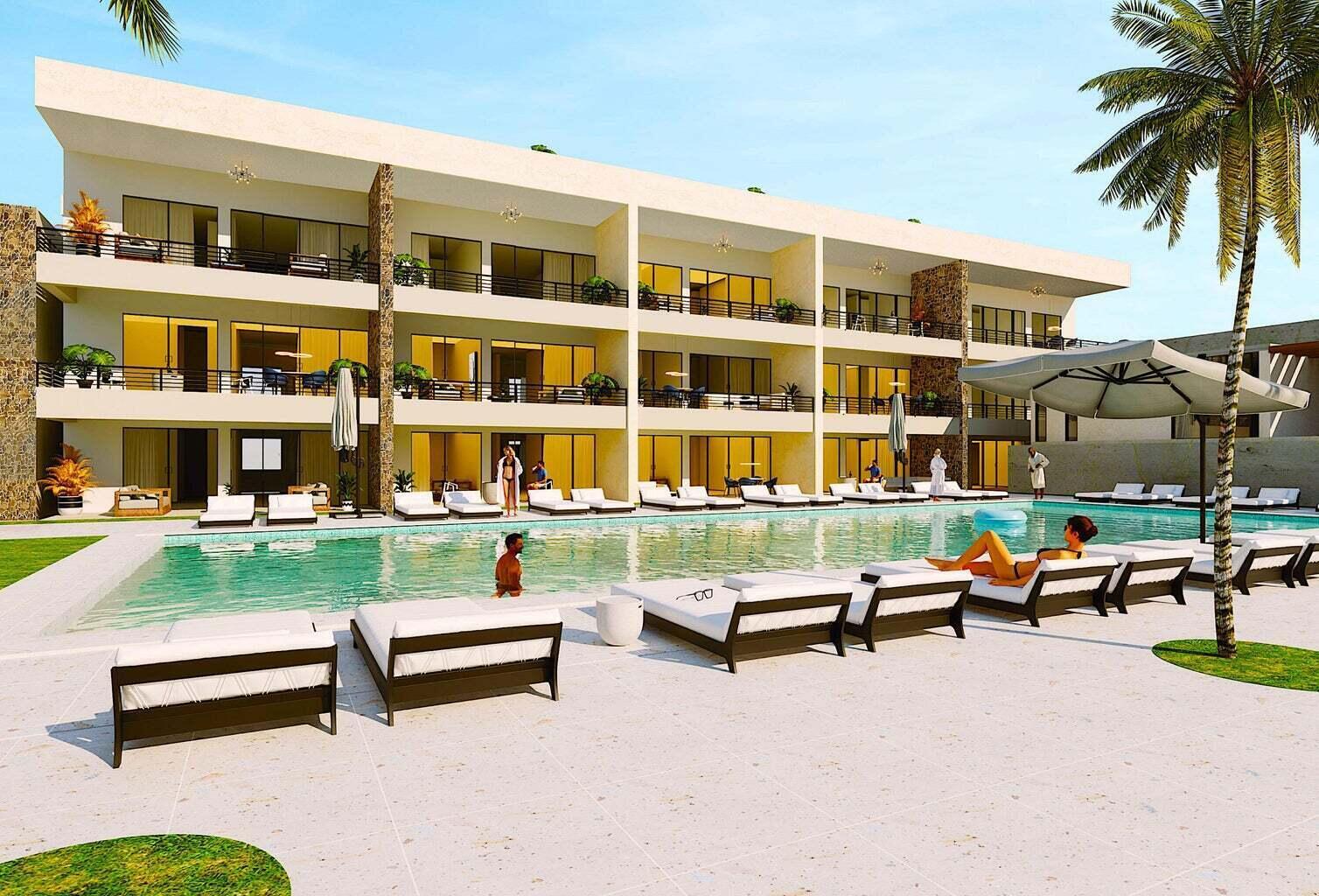 Tramonti Paradiso condominium balconies overlook a pool lined with sun loungers.