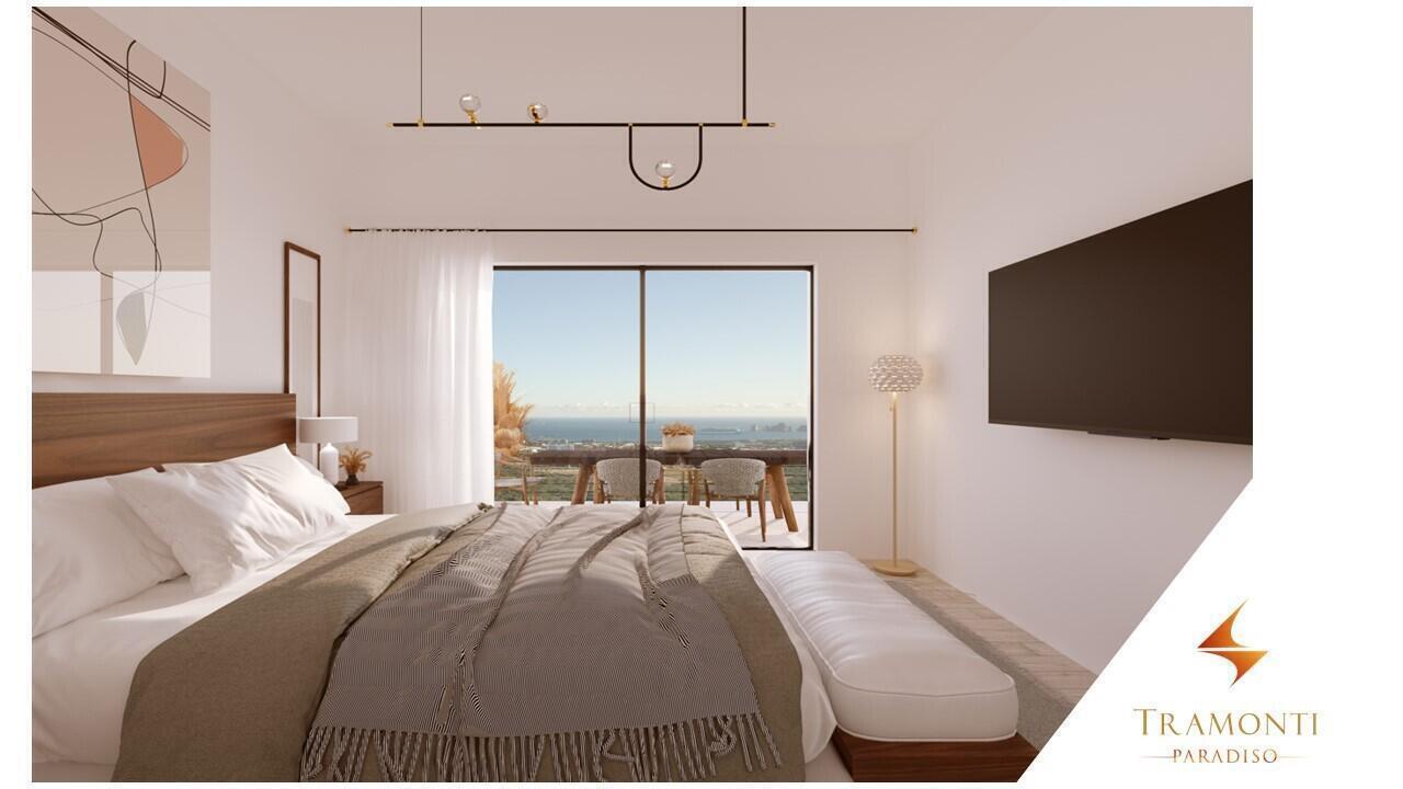 Penthouse bedroom with a king bed, upholstered bench, and ocean view through sliding glass doors.
