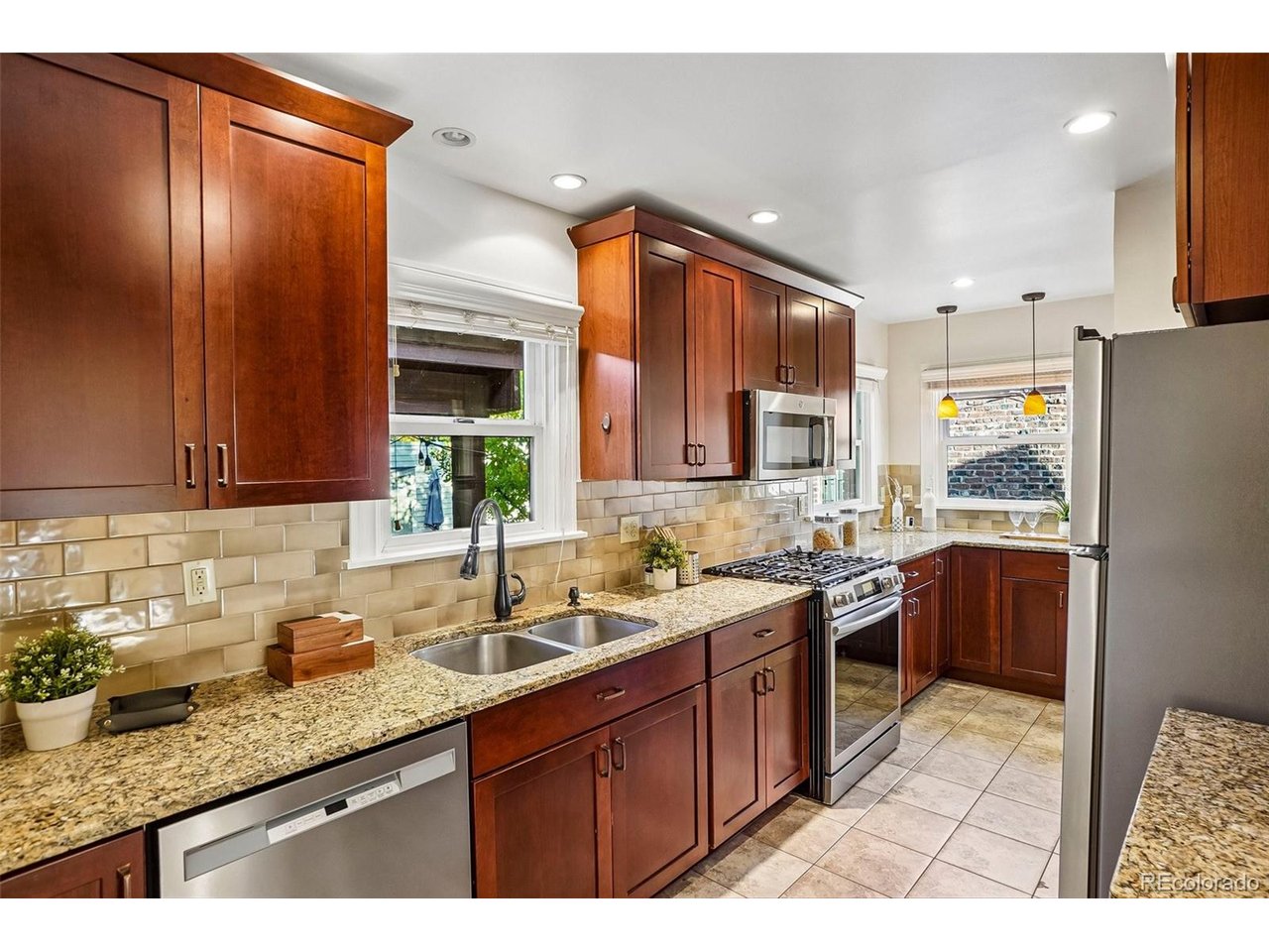 Kitchen with cherry cabinets, granite counters, stainless steel appliances, and a double-basin sink.