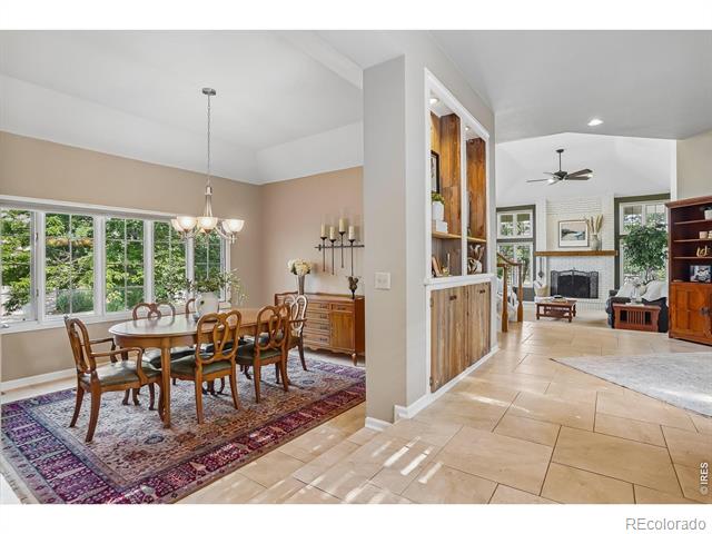 Dining and living areas with a window-side table, patterned rug, and built-in wood cabinet.
