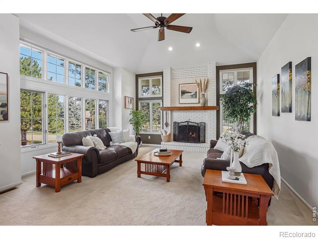 Staged living room with tall windows, a white brick fireplace, and two sofas.