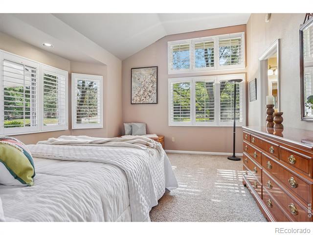 Bedroom with two beds, plantation-shuttered windows, carpet, and a wooden dresser.