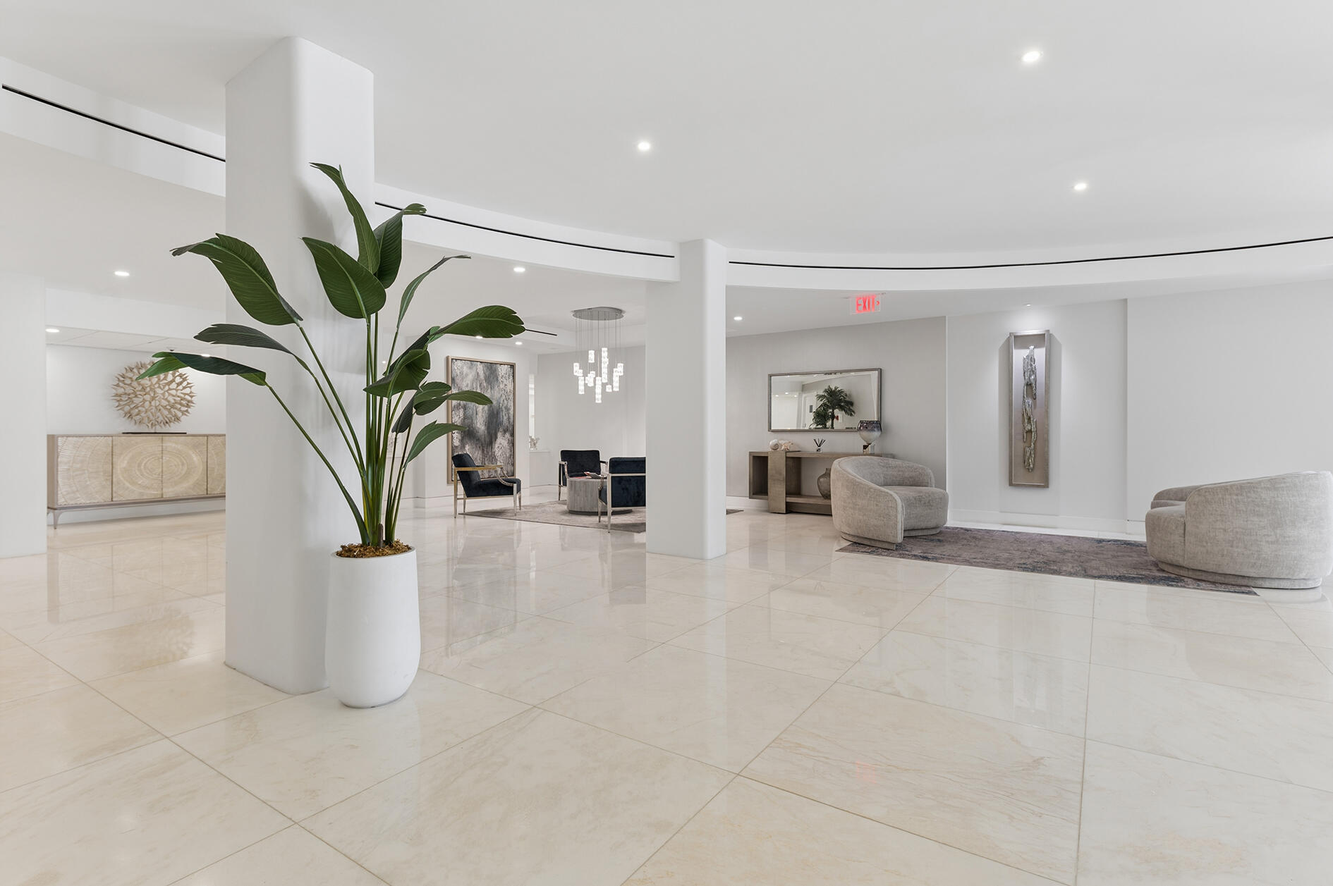Bright condominium lobby with polished tile floors, a sculptural plant, and contemporary lounge seating.