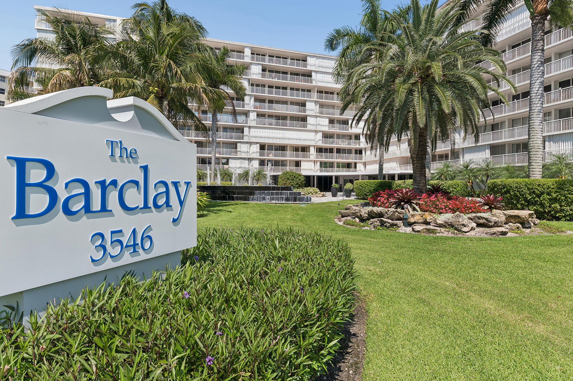 The Barclay condominium entrance, with its 3546 sign, palm trees, and landscaped grounds.