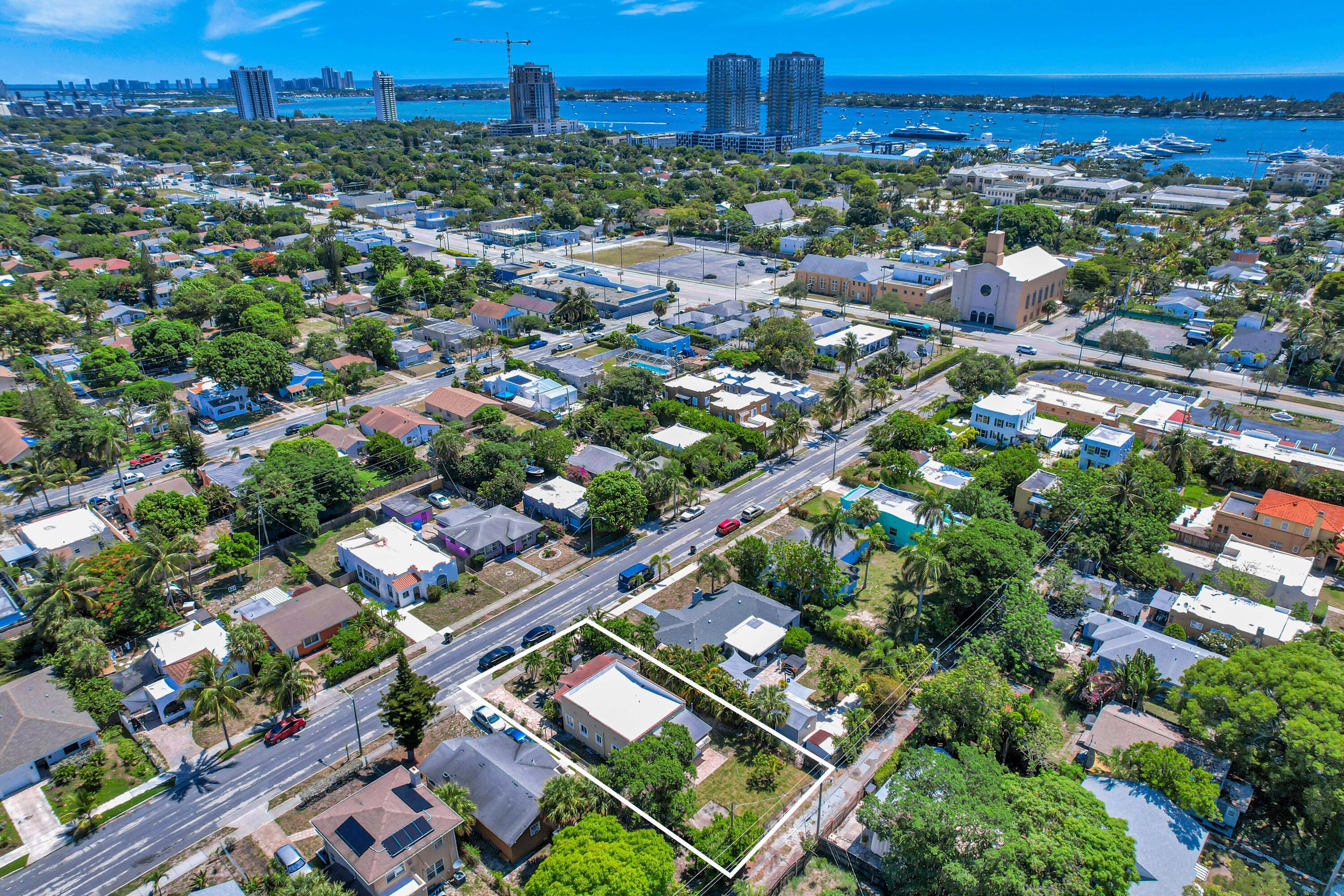 Aerial view of the outlined property lot among West Palm Beach homes, with waterfront and high-rises beyond.