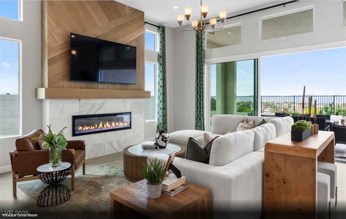 Living room with a marble fireplace, wood-paneled TV wall, and sliding glass doors to a balcony.