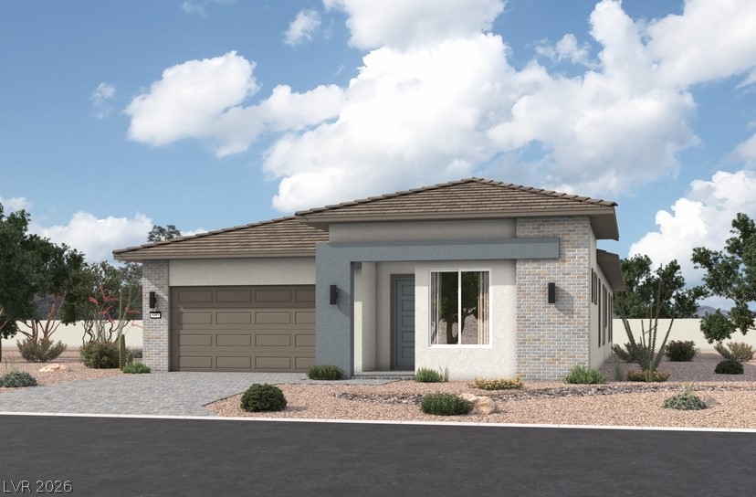 Single-story modern home with a tiled roof, double garage, and desert landscaping.