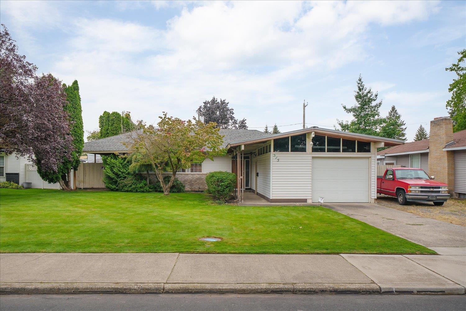 Single-story home with clerestory windows above the garage and a broad green front lawn.