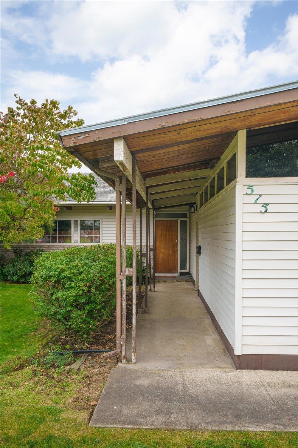 House entrance with a covered walkway leading to a wooden front door, marked 515.