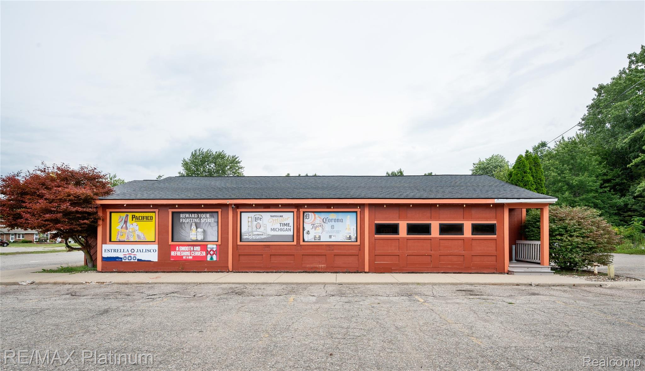 Red-orange commercial building with advertising panels across its front and a garage-style door.