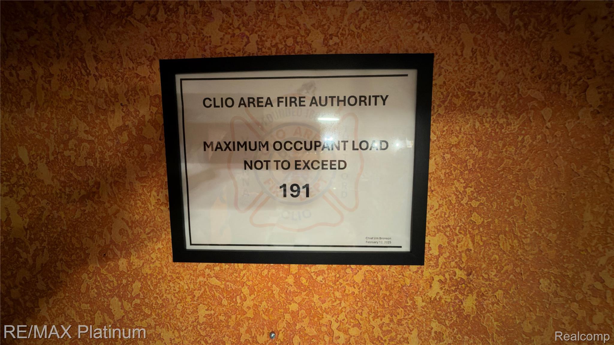 Framed Clio Area Fire Authority notice listing a maximum occupant load of 191.