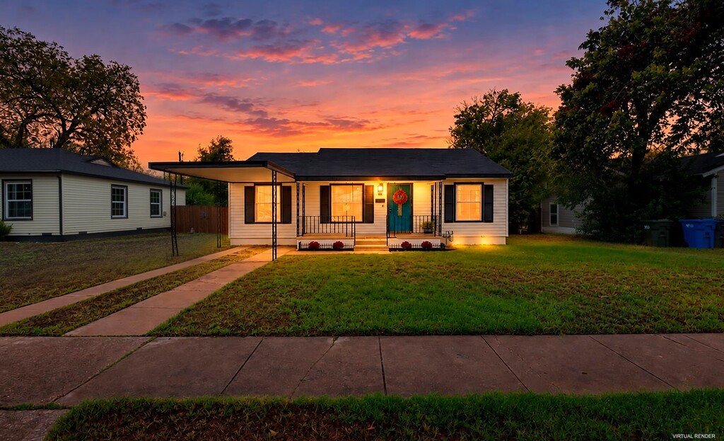 Single-story home with a teal front door and illuminated windows beneath a vivid sunset sky.