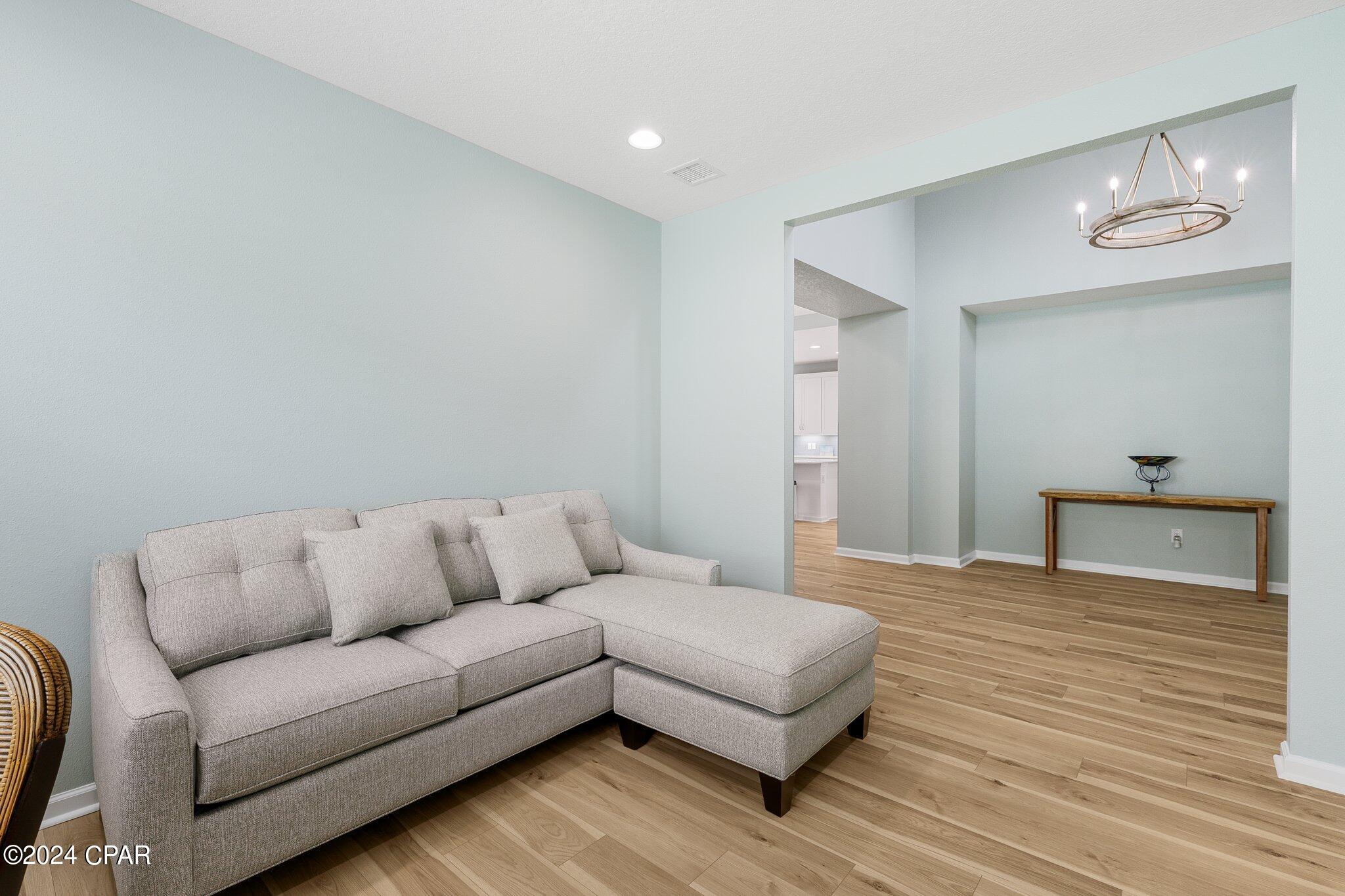 Living room with a gray sectional sofa, wood-look flooring, and a recessed wall niche.