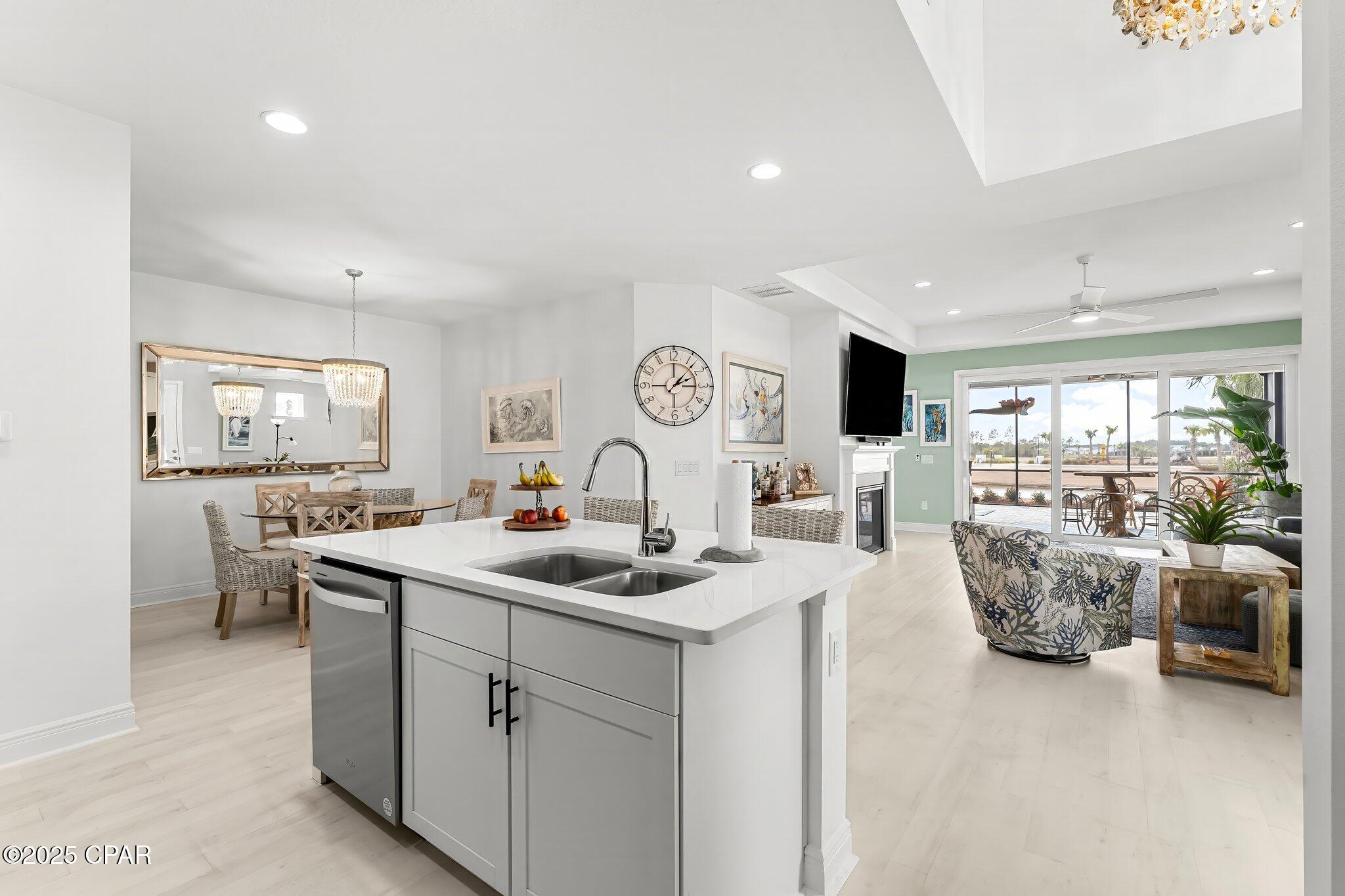 Open-plan kitchen and living area with a large white island and sliding doors to a patio.