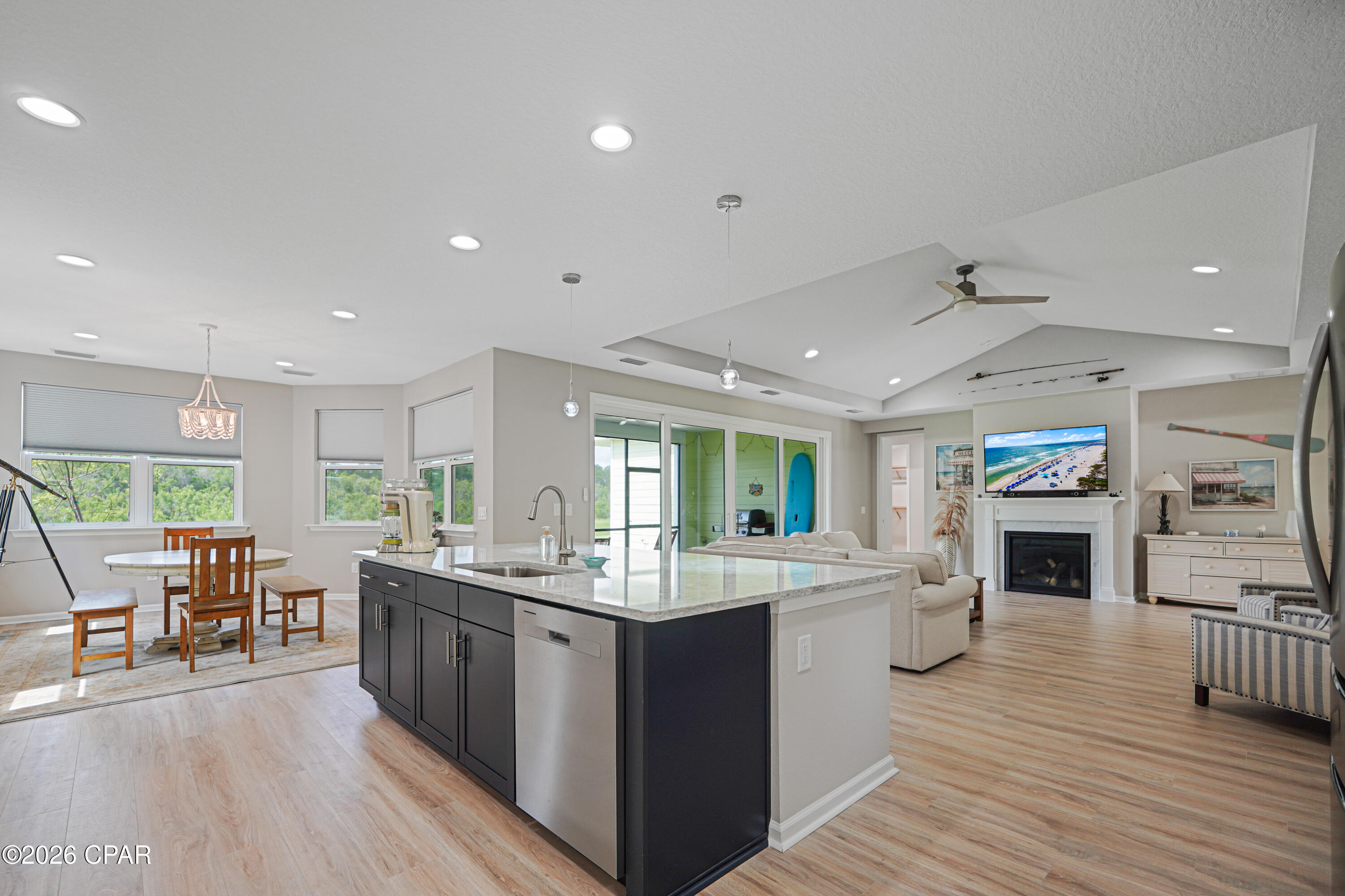 Open-plan kitchen and living area with a large island, dining nook, and fireplace.