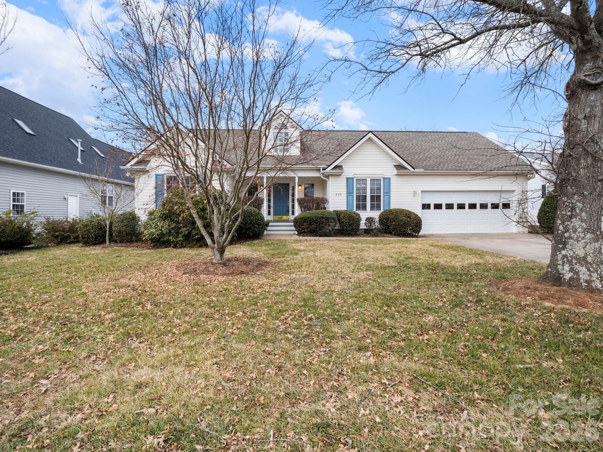 White single-story house with blue shutters, a blue front door, and an attached garage.