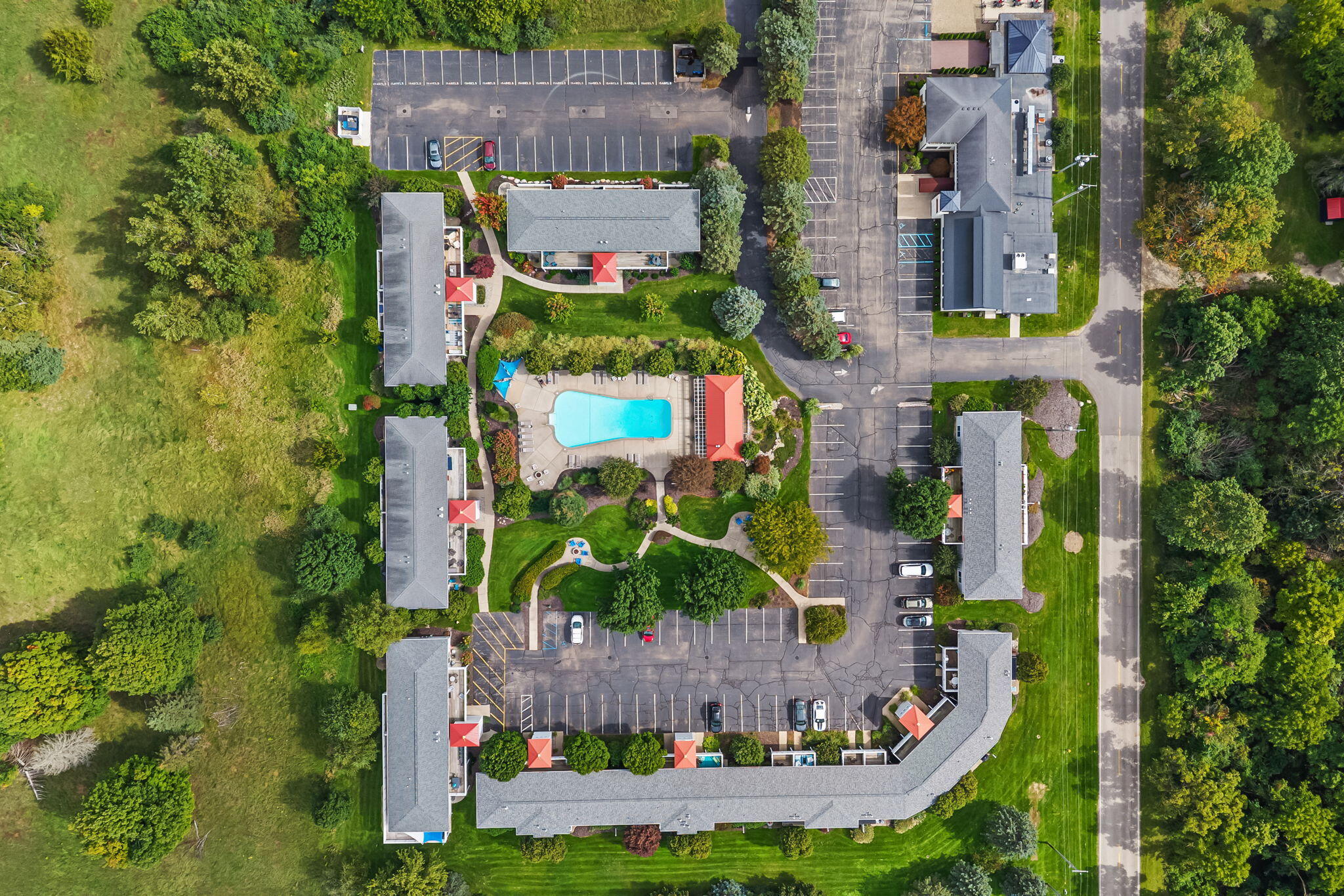 Aerial view of a multi-building property with a central swimming pool and landscaped grounds.