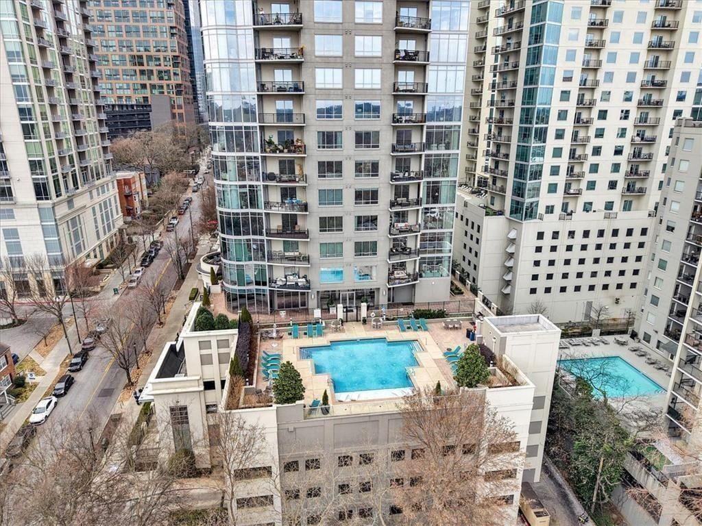 High-rise residences with balconies surround a courtyard swimming pool.