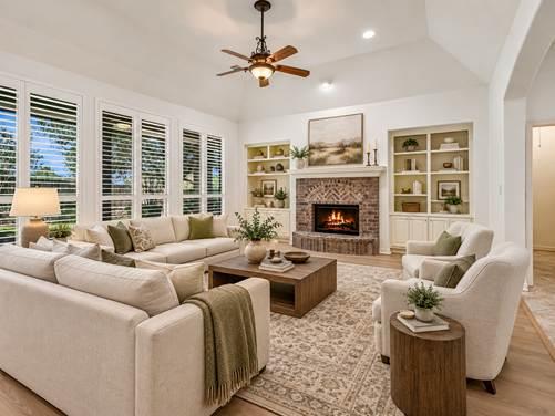 Living room with a stone fireplace, built-in shelves, and cream seating around a wood coffee table.