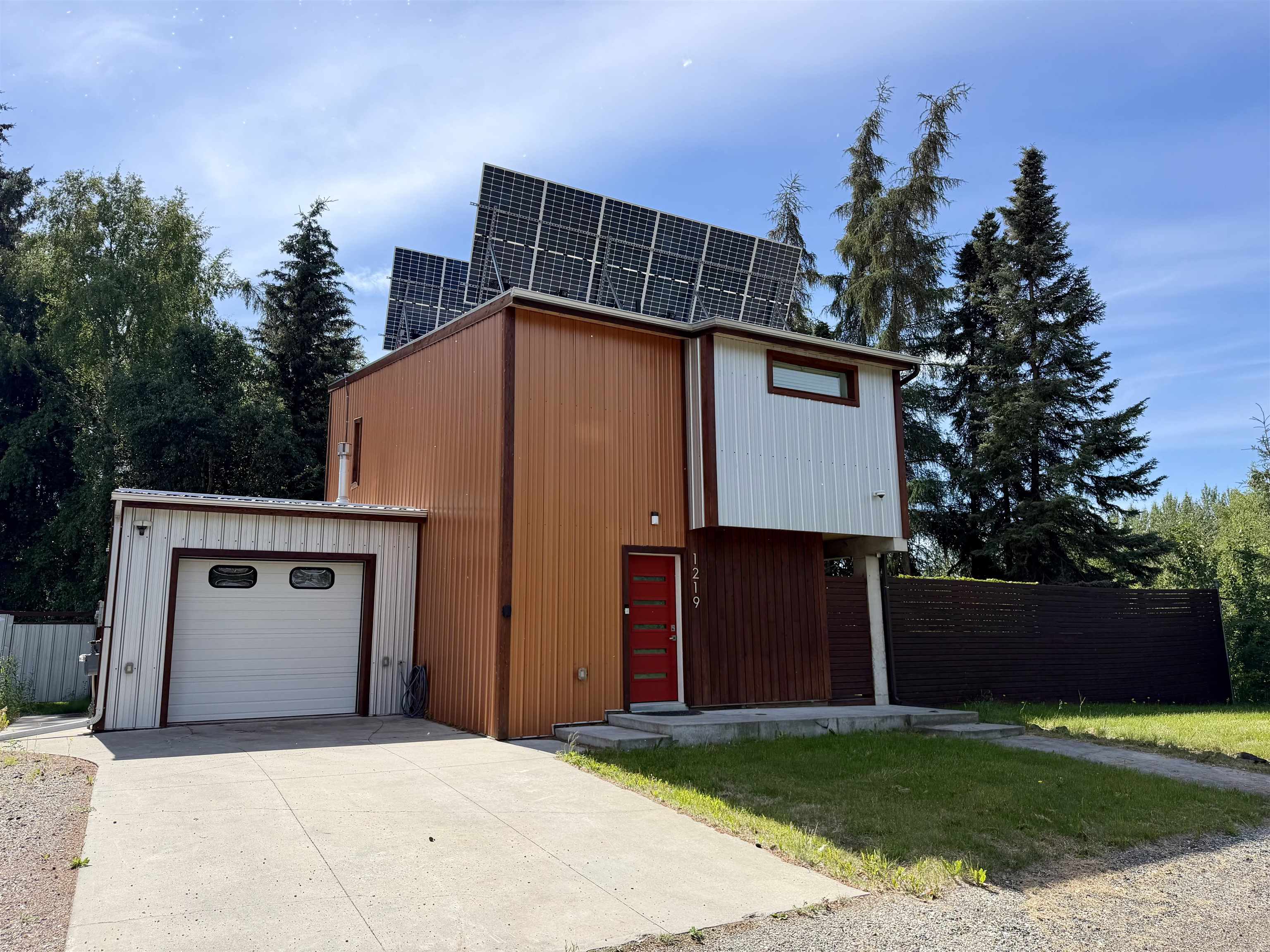 Two-story home with rooftop solar panels, brown-and-white siding, and an attached garage.