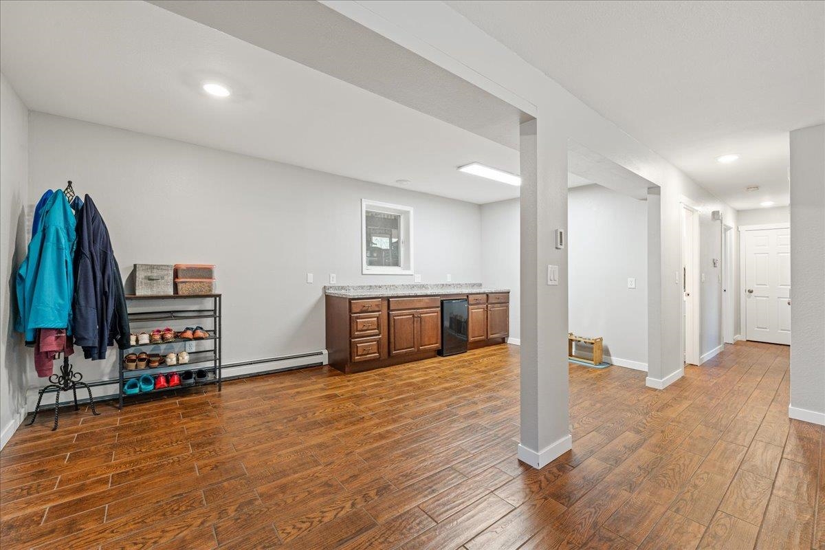 Open kitchen with wood-tone cabinets and an oven, adjoining a hallway with wood-look tile flooring.