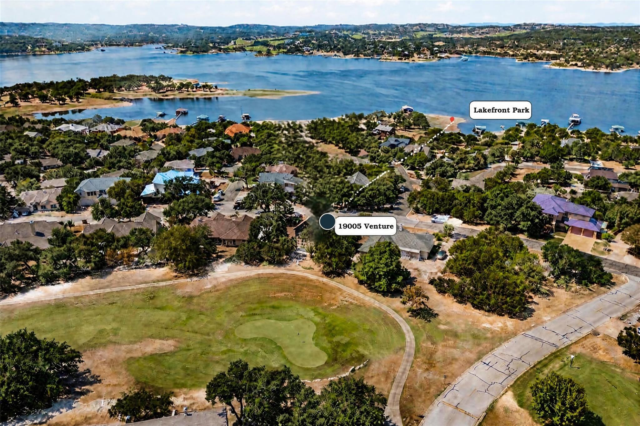 Aerial view of 19005 Venture near Lakefront Park, with a golf green and lake shoreline.