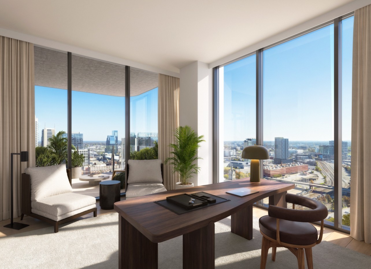 High-rise home office with a dark wood desk and floor-to-ceiling windows overlooking the city.
