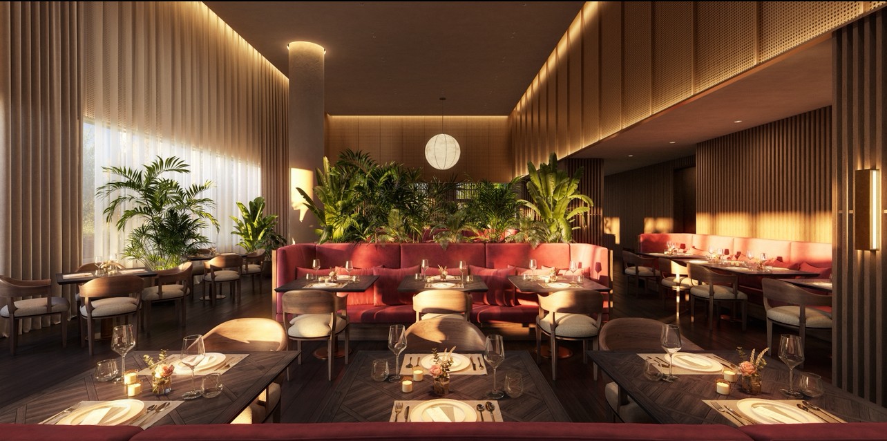 Dining area with red banquette seating, set tables, abundant plants, and tall sunlit windows.