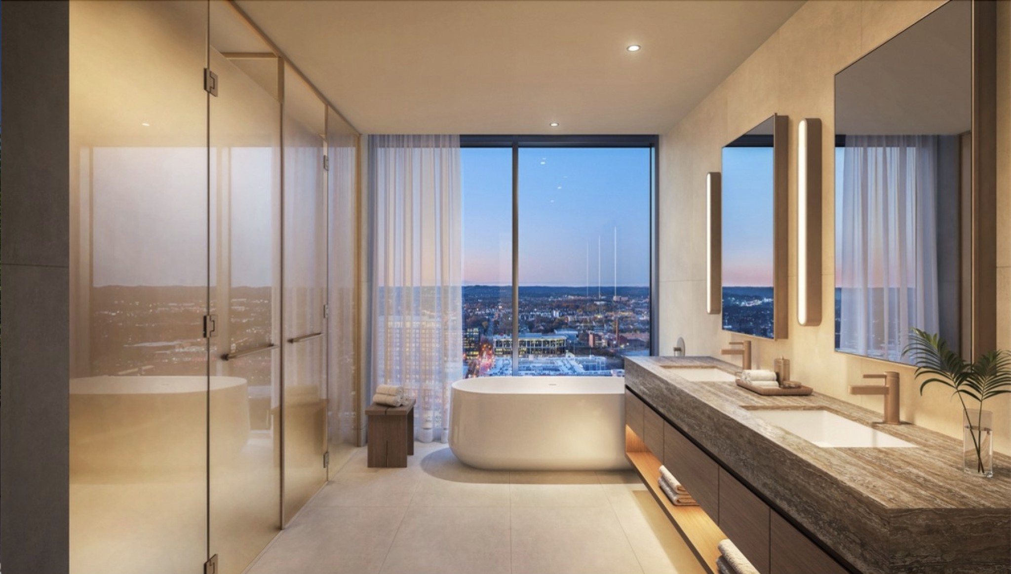 Modern bathroom with a freestanding tub and double vanity overlooking the city skyline.