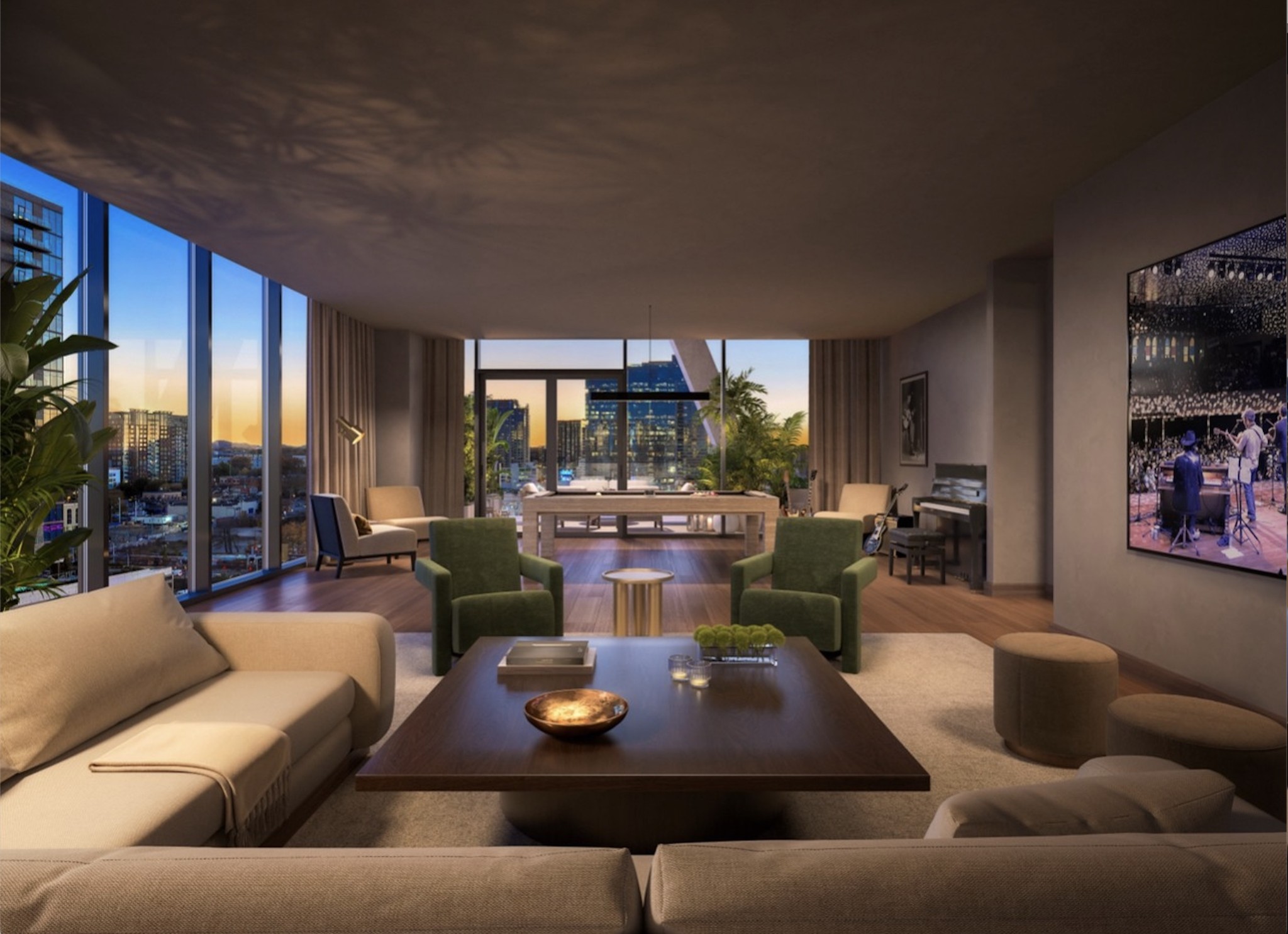 Furnished condo living room with floor-to-ceiling windows overlooking the city skyline at dusk.