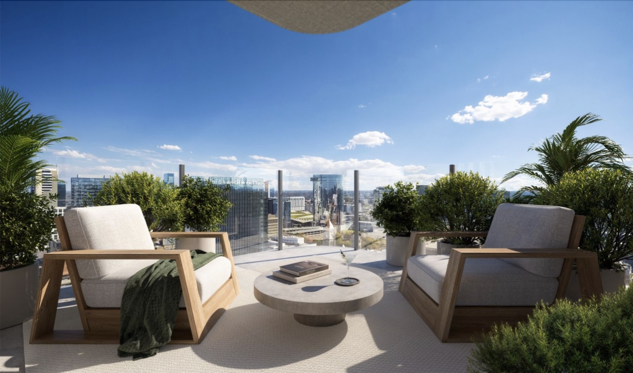 Furnished rooftop terrace with lounge chairs and potted greenery overlooking the city skyline.