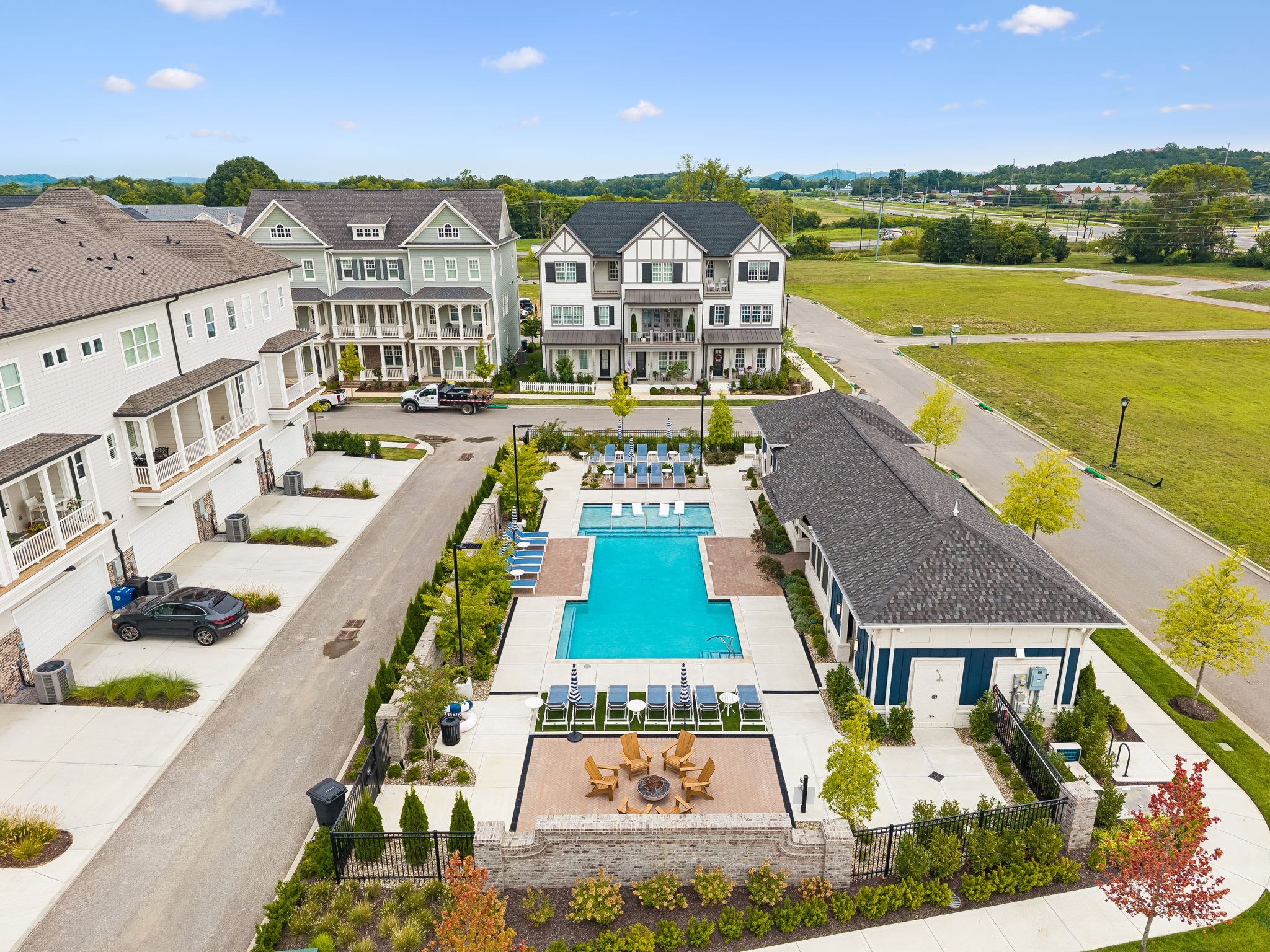 Aerial view of townhomes around a community pool and landscaped patio.