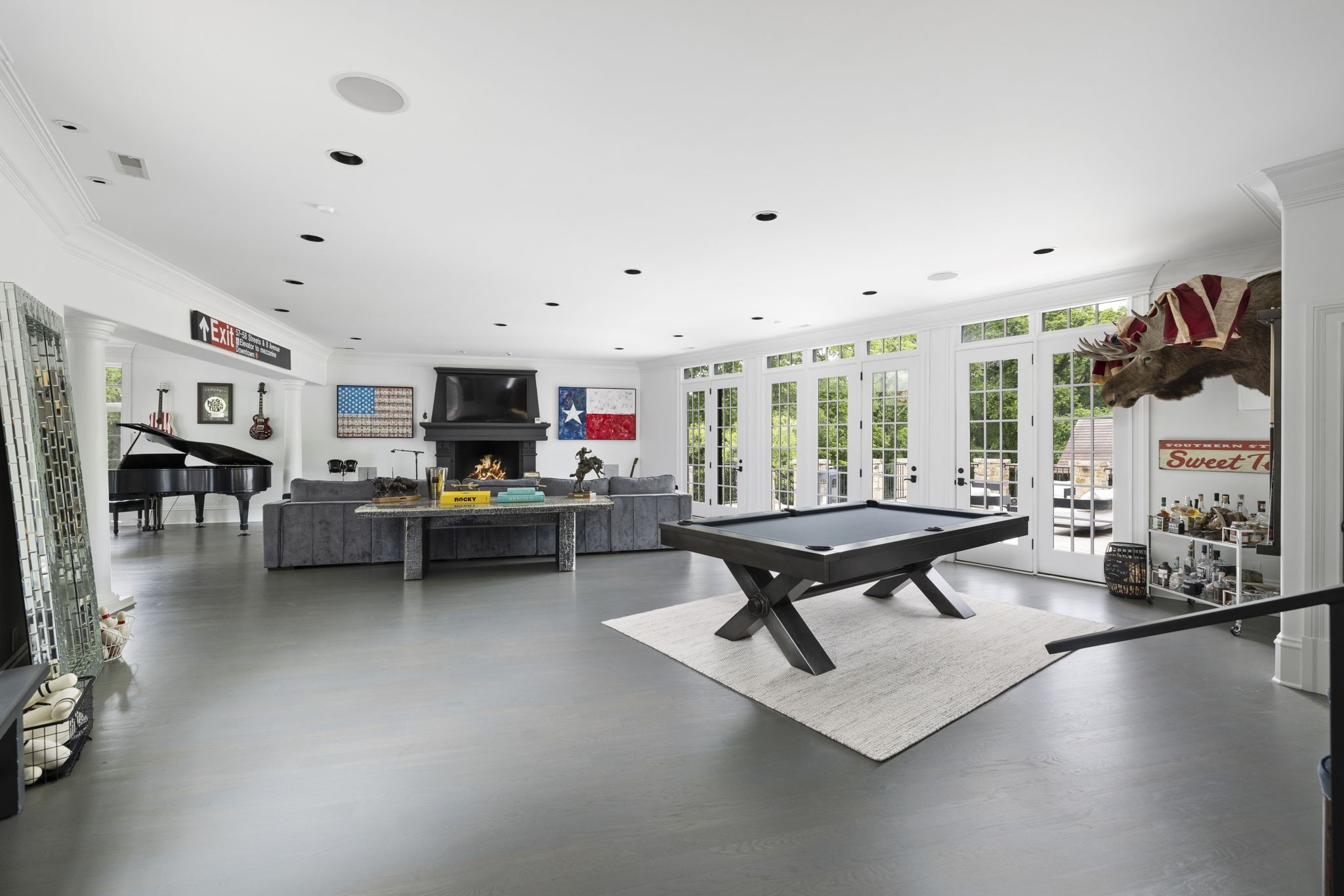 Game room with a pool table, grand piano, fireplace, and mounted moose head.