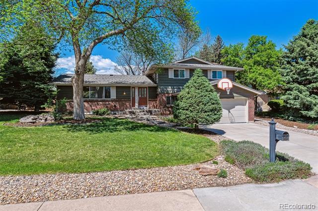Split-level home with brick and siding, an attached garage, and a basketball hoop by the driveway.