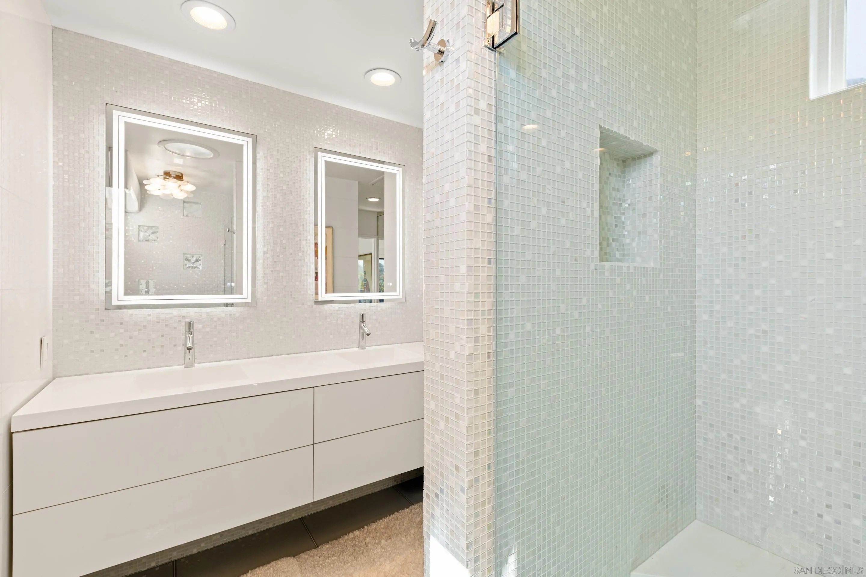 Primary bathroom at 194 Neptune Ave-Encinitas-CA-92024 featuring double-sink vanity, LED-lit mirrors, mosaic tile walls, and a glass-enclosed walk-in shower in this oceanfront Neptune Avenue home listed by FW Property Group