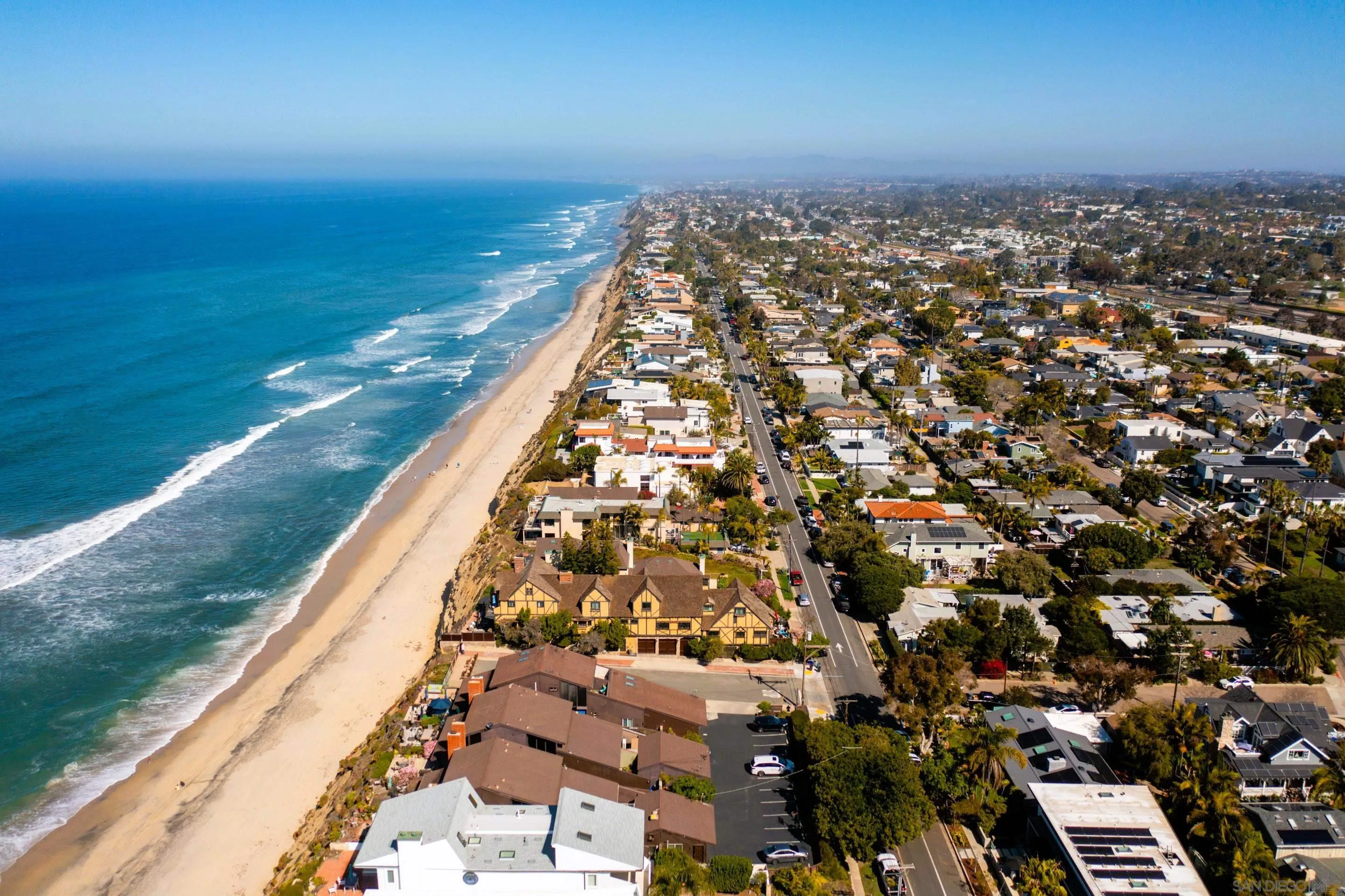 Aerial view of Leucadia beachfront near 194 Neptune Ave-Encinitas-CA-92024 showcasing sandy shoreline, deep blue ocean, and coastal homes in a scenic beachside community listed by FW Property Group