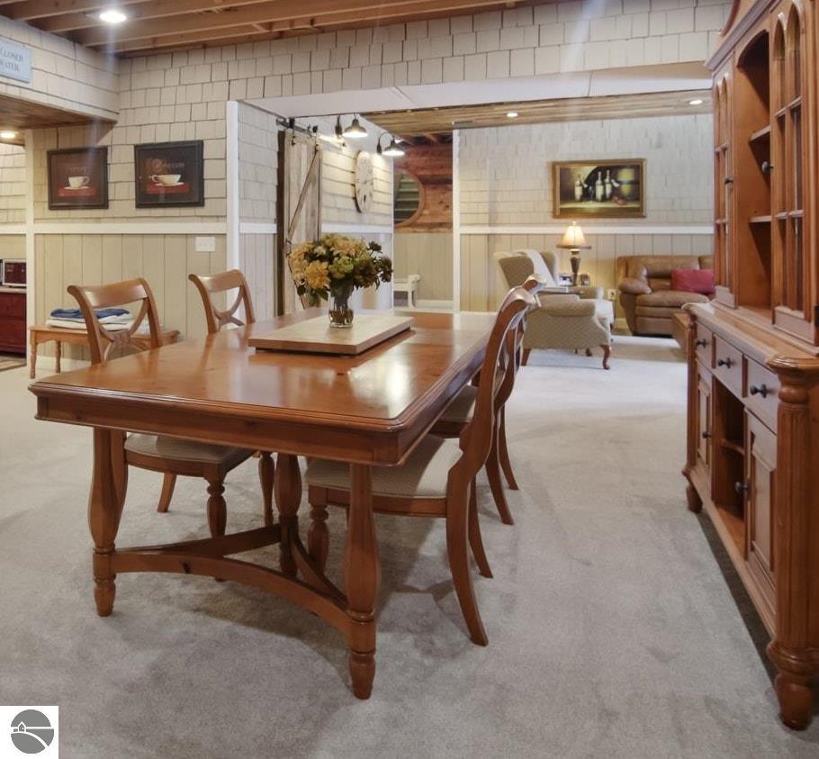 Furnished dining room with a large wooden table, built-in cabinetry, and an adjoining sitting area.