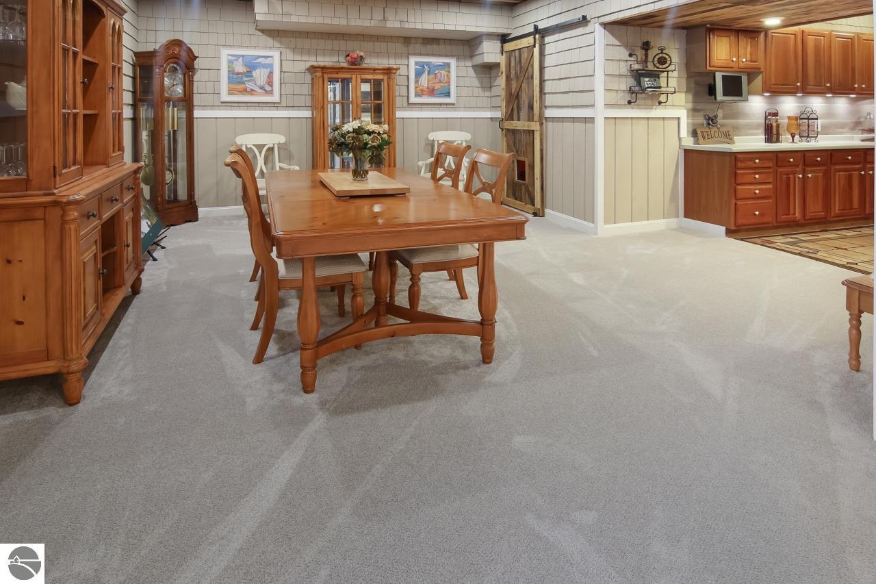 Dining room with a wooden table and chairs, built-in cabinetry, and an adjoining kitchen.