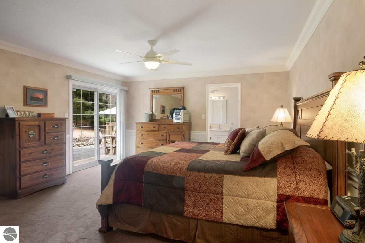 Bedroom with a patchwork quilt, wooden furniture, and a sliding glass door to the patio.