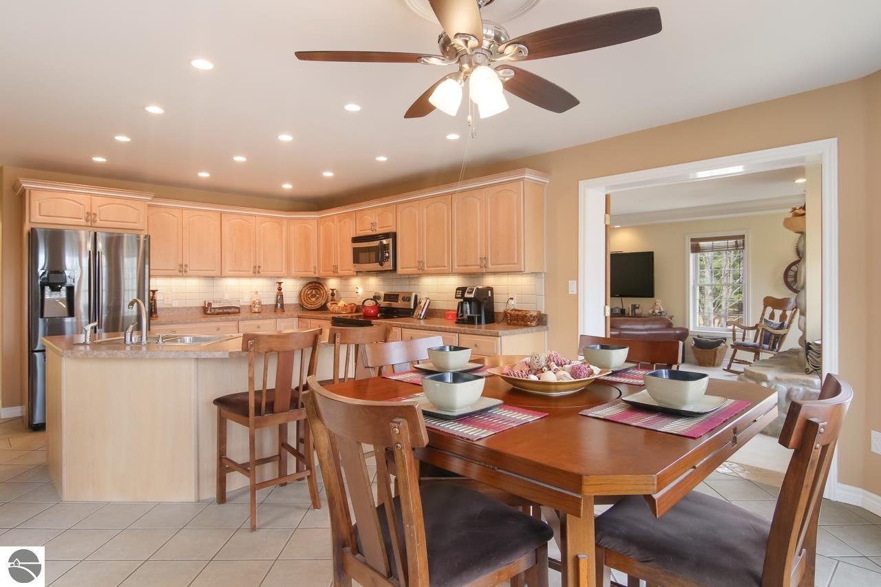 Kitchen and dining area with light wood cabinets, stainless appliances, and a large set dining table.