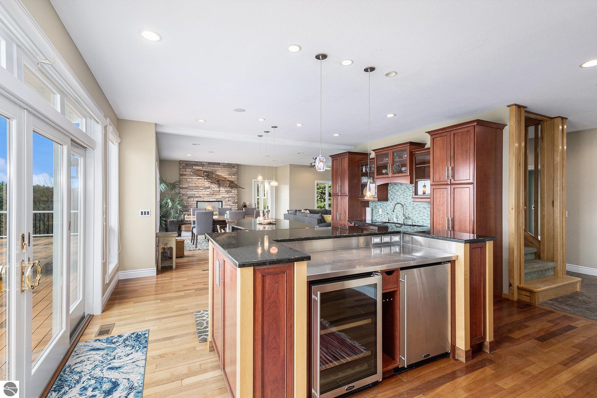 Kitchen with a large island, rich wood cabinetry, stainless steel appliances, and sliding doors to a deck.