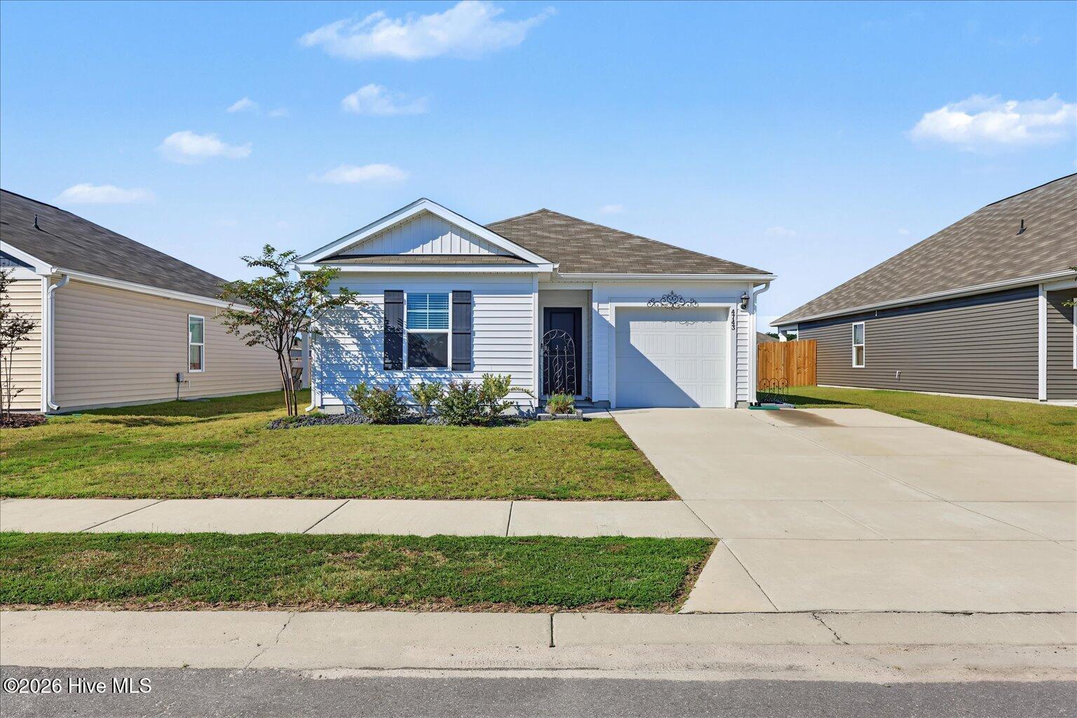 White single-story home with dark shutters, a covered entry, and an attached garage.