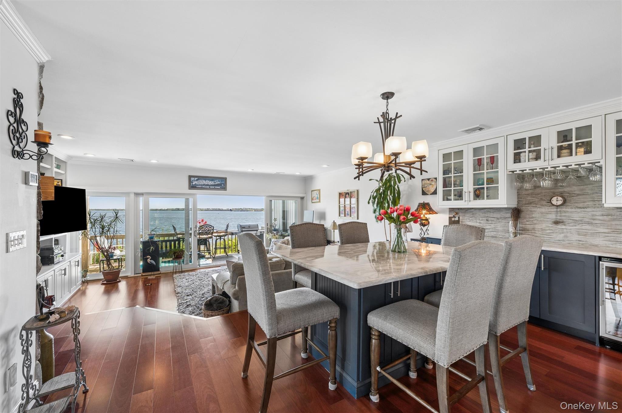 Kitchen and dining area with a large island and sliding doors overlooking the water.
