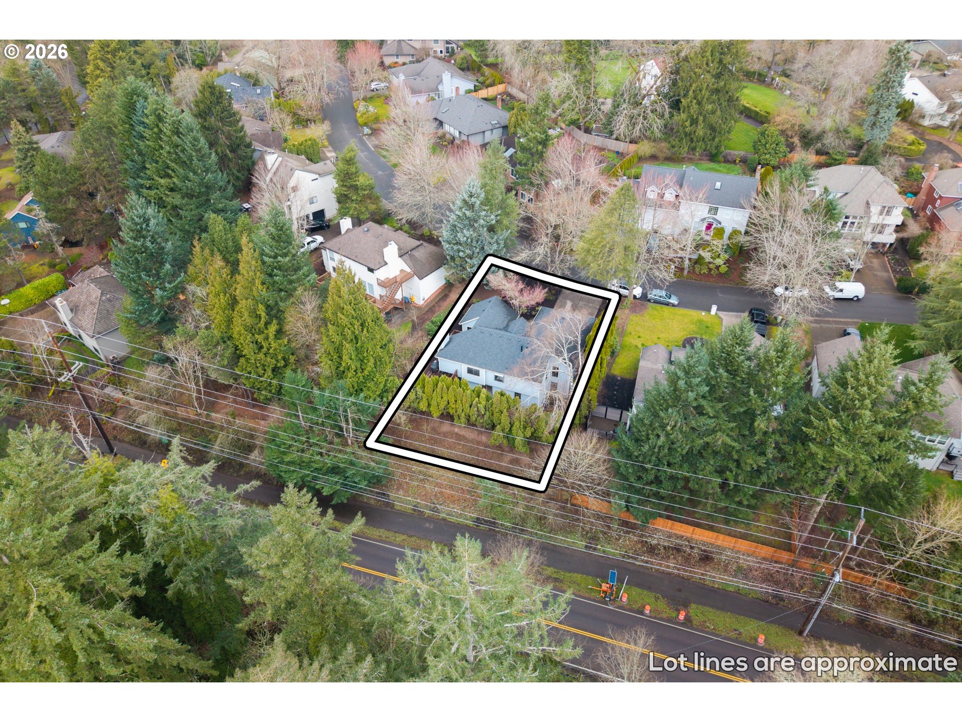 Aerial view of a house and its approximate lot lines among trees and neighboring homes.