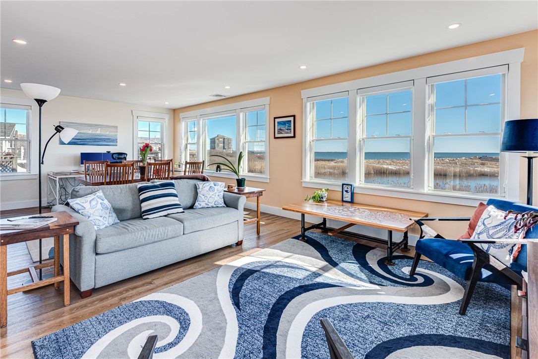 Living room with large windows overlooking marsh grass and water.