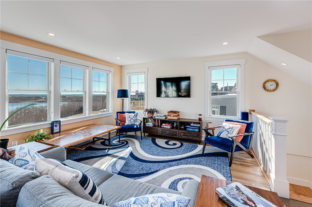 Living room with blue-and-white furnishings and large windows overlooking water and marshland.