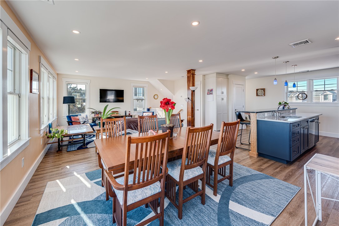 Open-plan dining area with a wooden table, living room, and navy kitchen island.