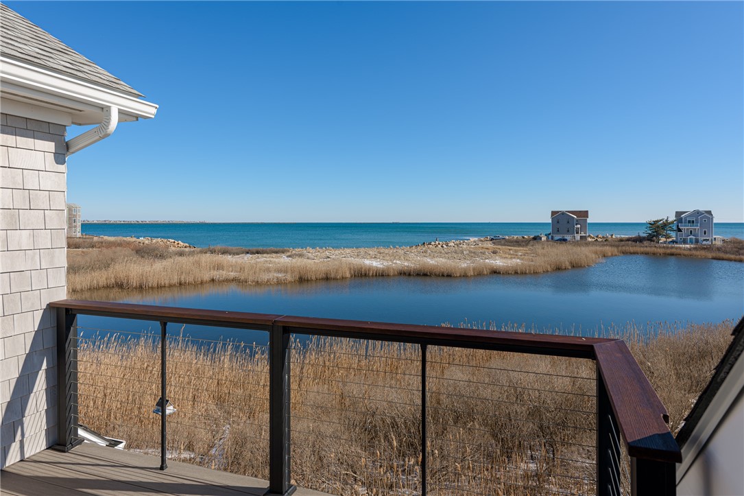Deck overlooking a marsh pond and coastal grasses toward the ocean.